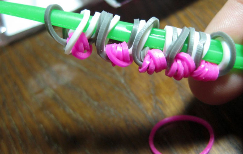 Взять фиолетовую резинку, протянуть её через все детали и завязать узелком