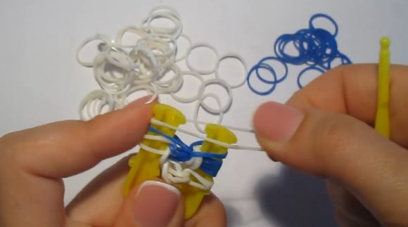 Плетение браслета из белых и синих резинок на рогатке