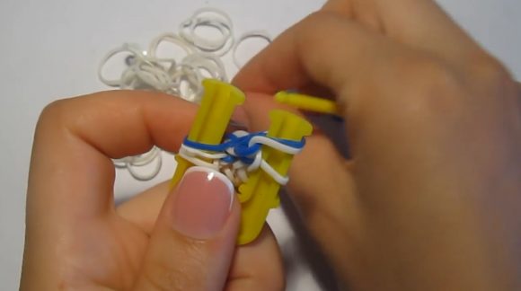 Процесс плетения браслета «Паучок» из резинок на жёлтой рогатке